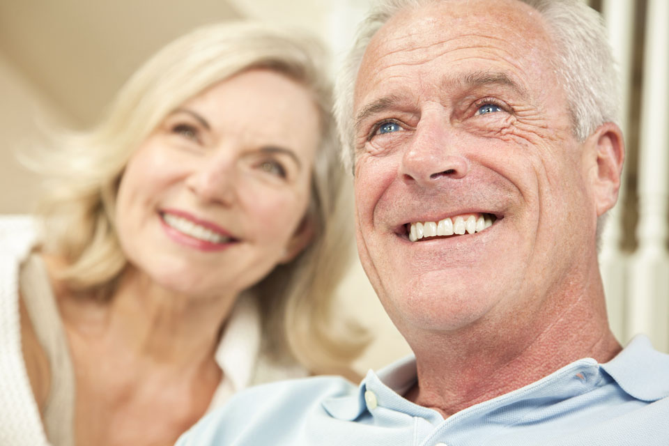 Seniorenpaar guckt in den Himmel und zeigt seine Zähne