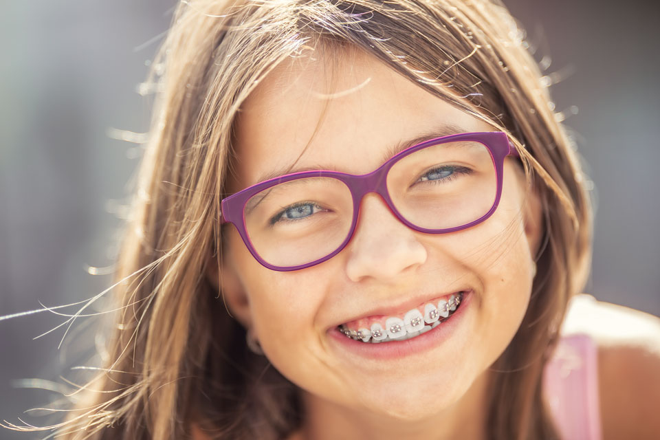Mädchen mit Zahnspange lächelt in die Kamera